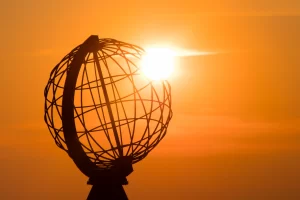 The midnight sun through the globe at North cape in Norway, the most northern point of Europe