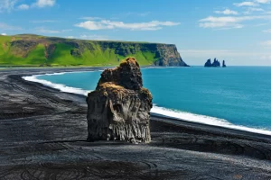 Beautiful rock formation on a black volcanic beach at Cape Dyrholaey, the most southern point of Iceland.