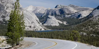 Scenic Tioga Pass road running through Sierra Nevada mountain scenery on sunny day in summer at Olmsted Point in Yosemite National Park.