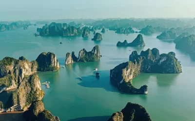 Vista aerea villaggio di pescatori galleggianti e isola rocciosa, Halong Bay, Vietnam, Sud-est asiatico. Patrimonio dell'umanità dell'UNESCO.